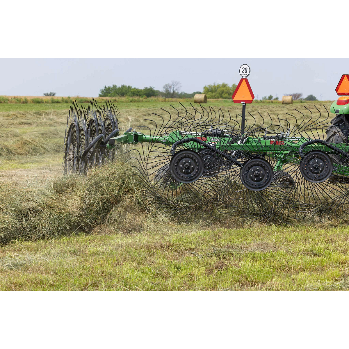 Rear right close-up of a WR3212 wheel rake at work on a pile of hay