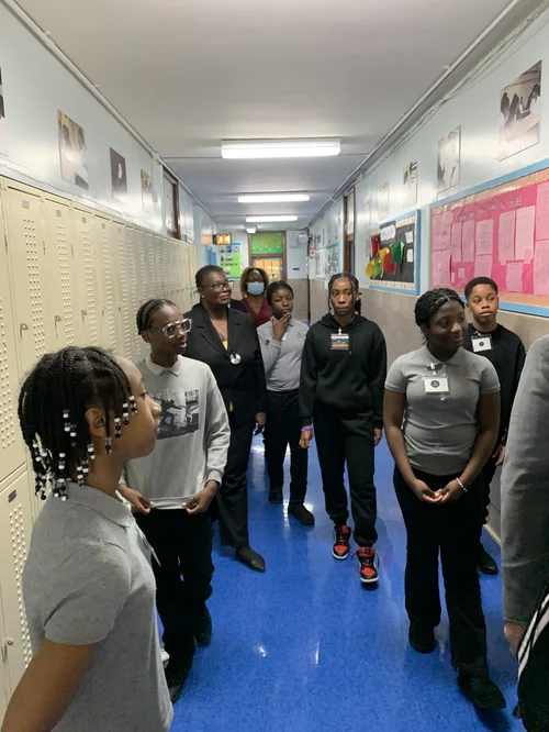 Group of students and a teacher standing and talking.