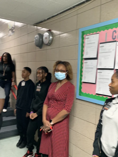 Group of people standing in a hallway.