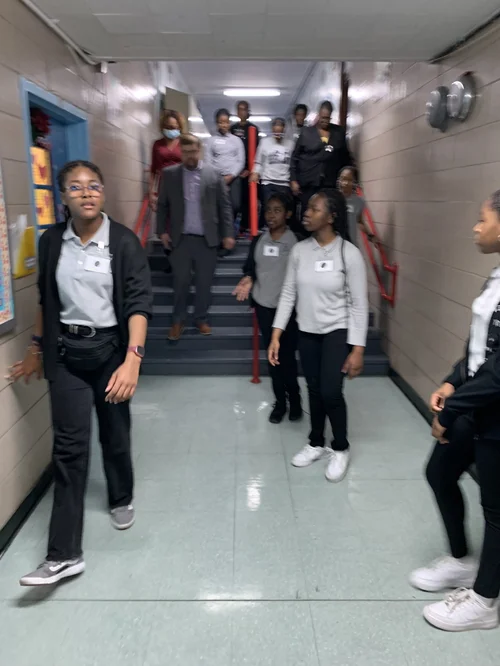 Group of students and an adult walking down 