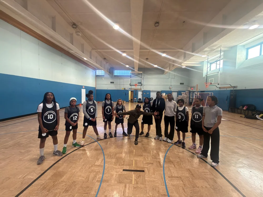 Youth basketball team standing on gym court in a row