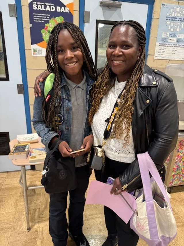 Two smiling women standing close together in an indoor setting .