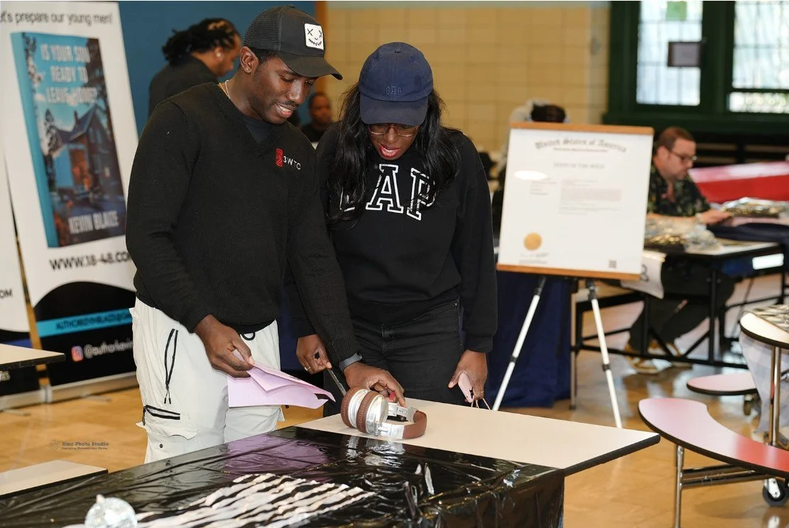 A man and woman examining a belt 