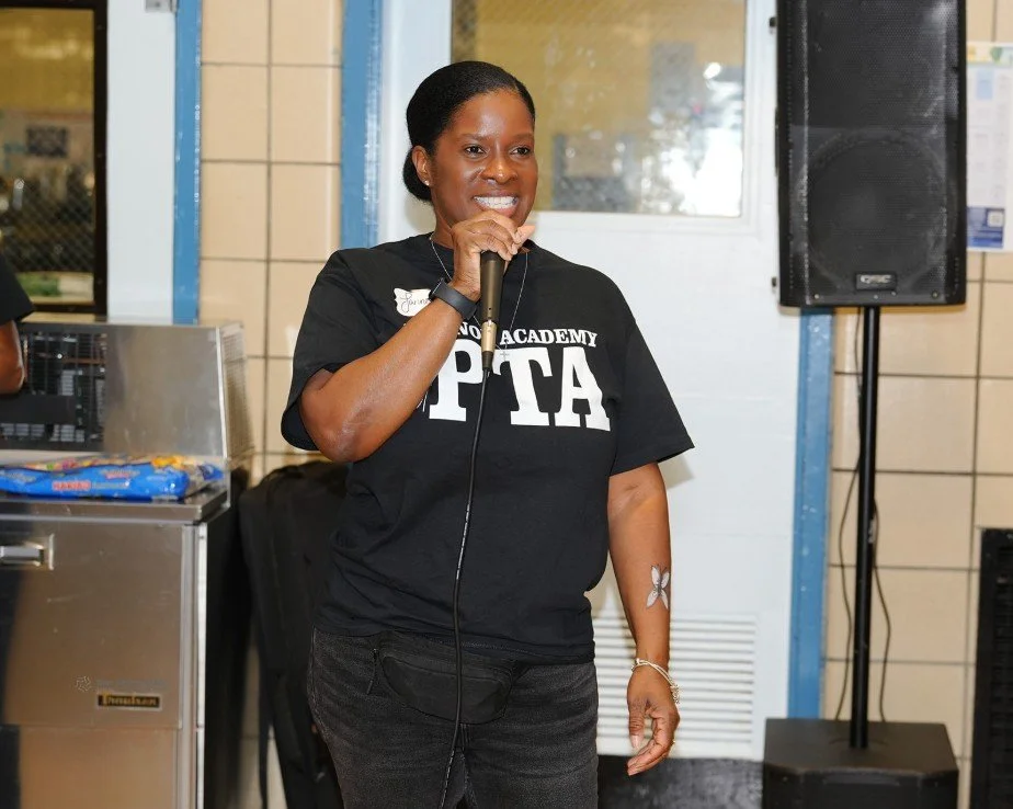 Woman speaking into a microphone wearing