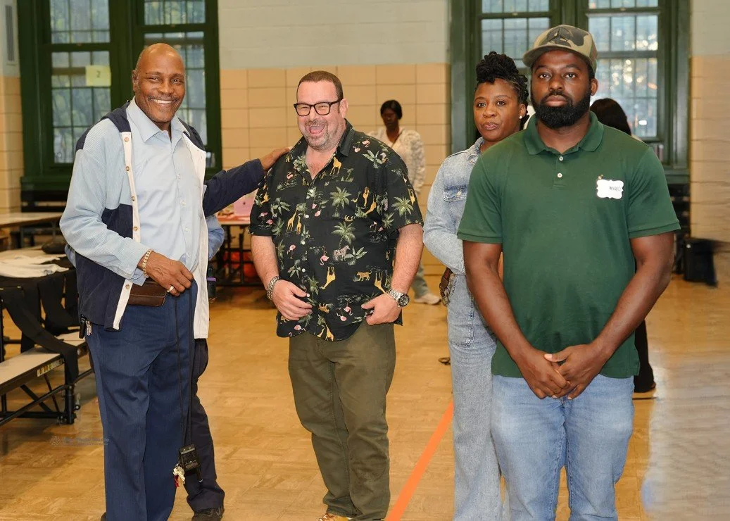 Four adults standing indoors in a gymnasium