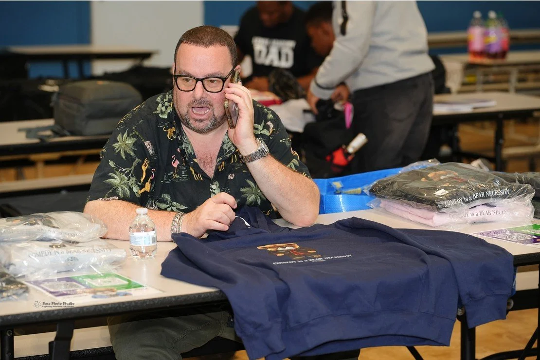 Man wearing a tropical print shirt and glasses talking on the phone