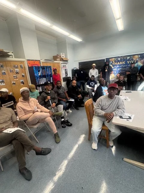 Group of people sitting and standing in a community room with chairs