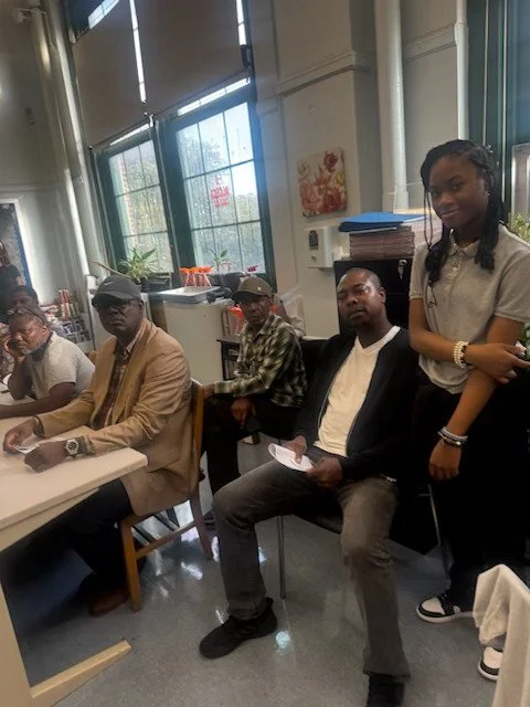 Five people, four seated and one standing