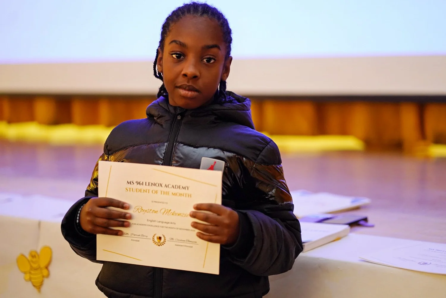 Student holding a certificate for Student of the Month 