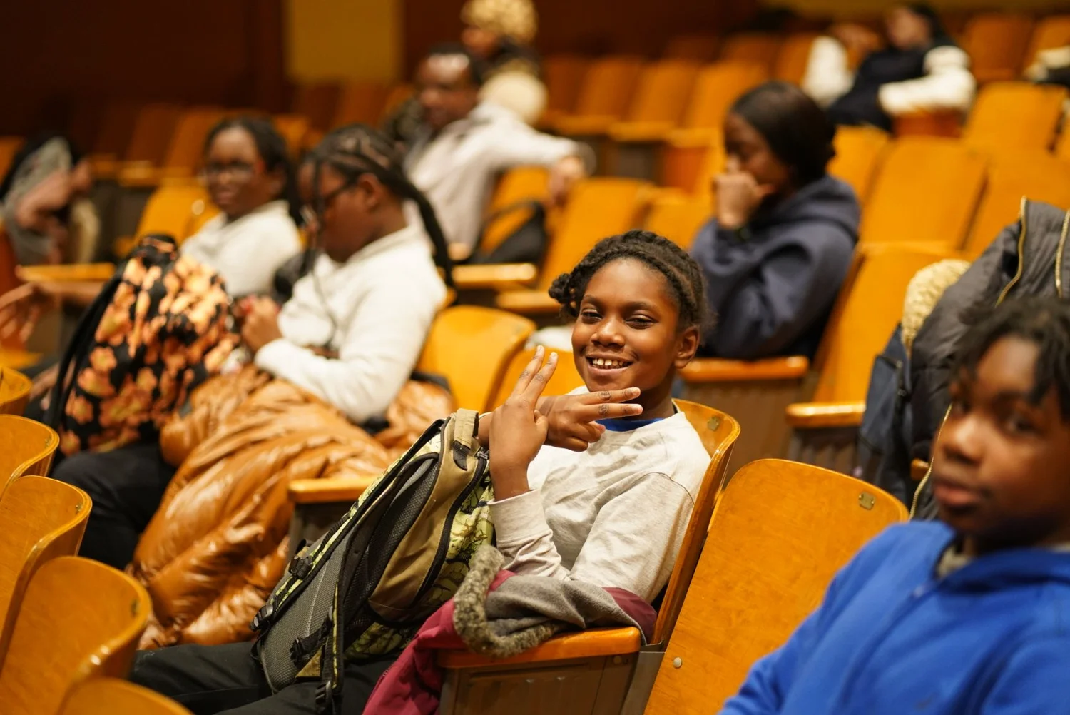 Smiling schoolchildren sitting in an auditorium