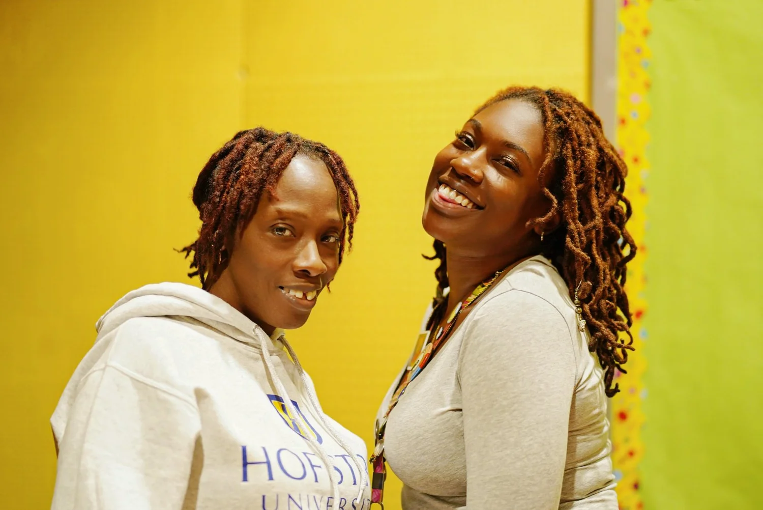 Two smiling Black women with braided hair 
