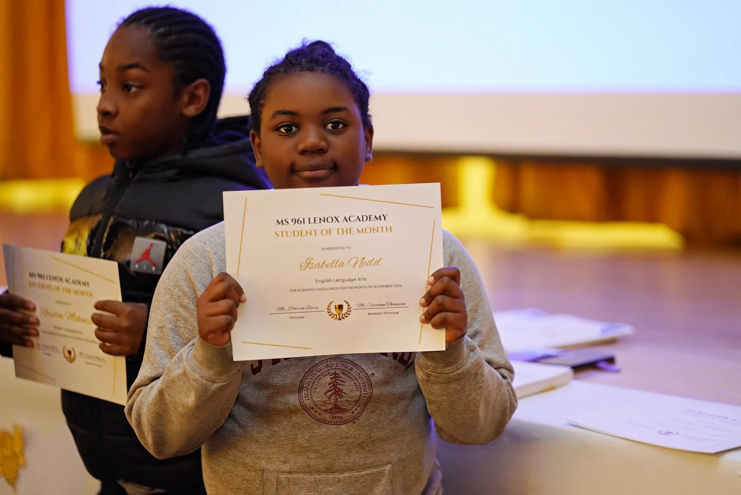 Student holding a certificate for Student of the Month