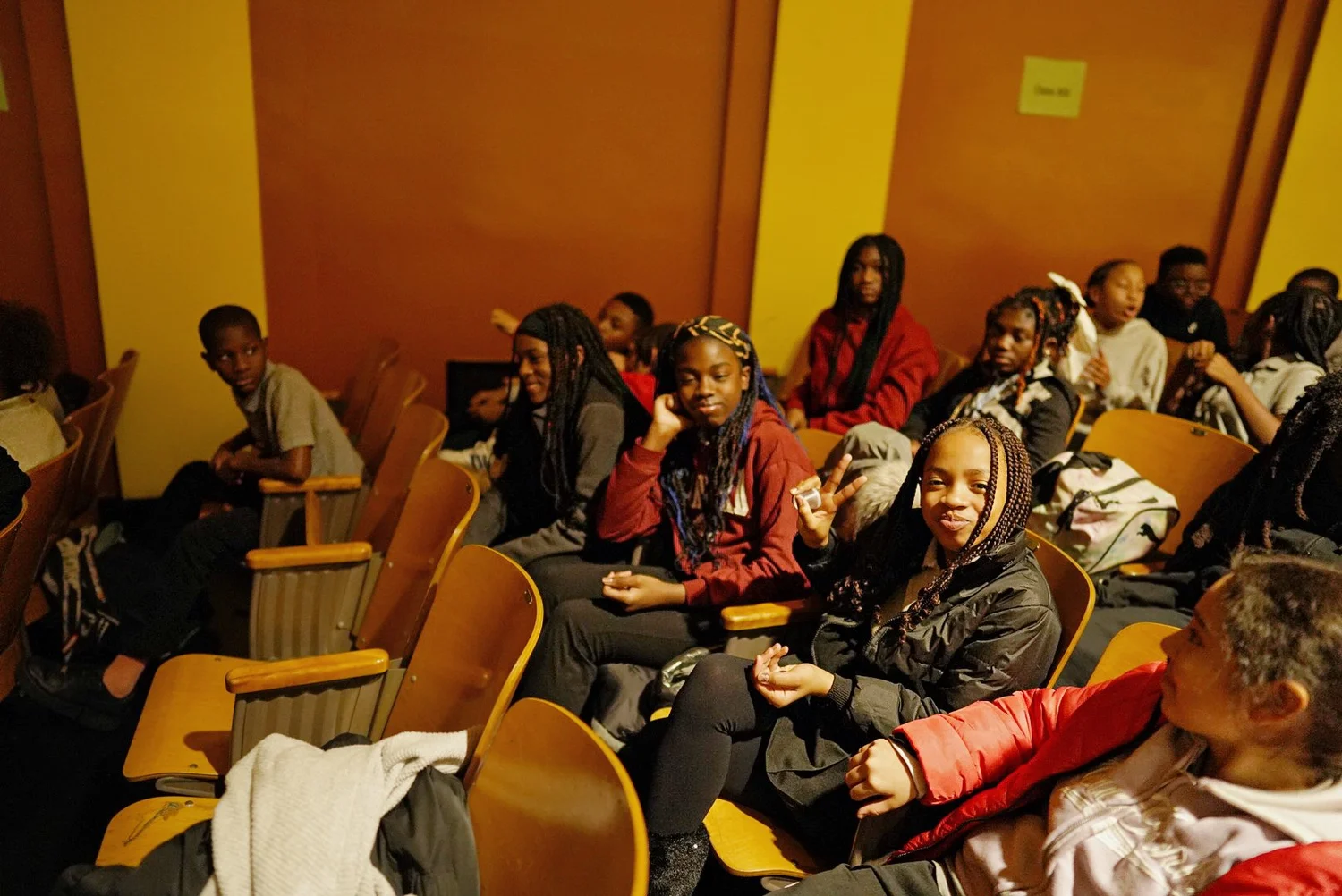 Group of young people seated in wooden chairs 