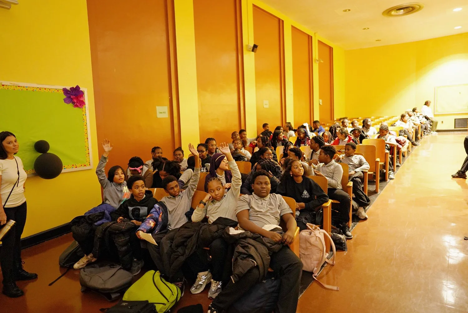 A group of schoolchildren sitting in an auditorium