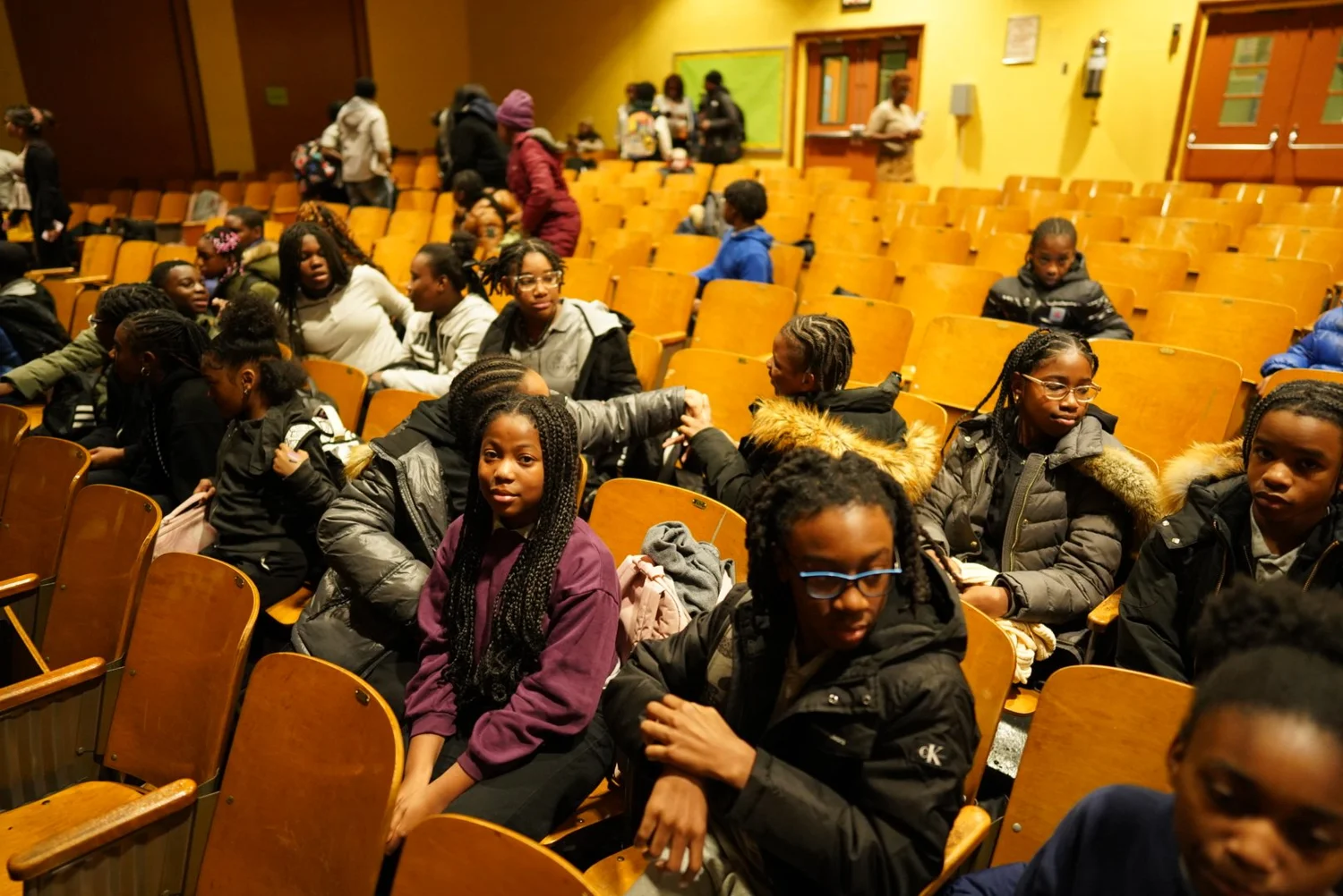A group of children and teenagers sitting and talking