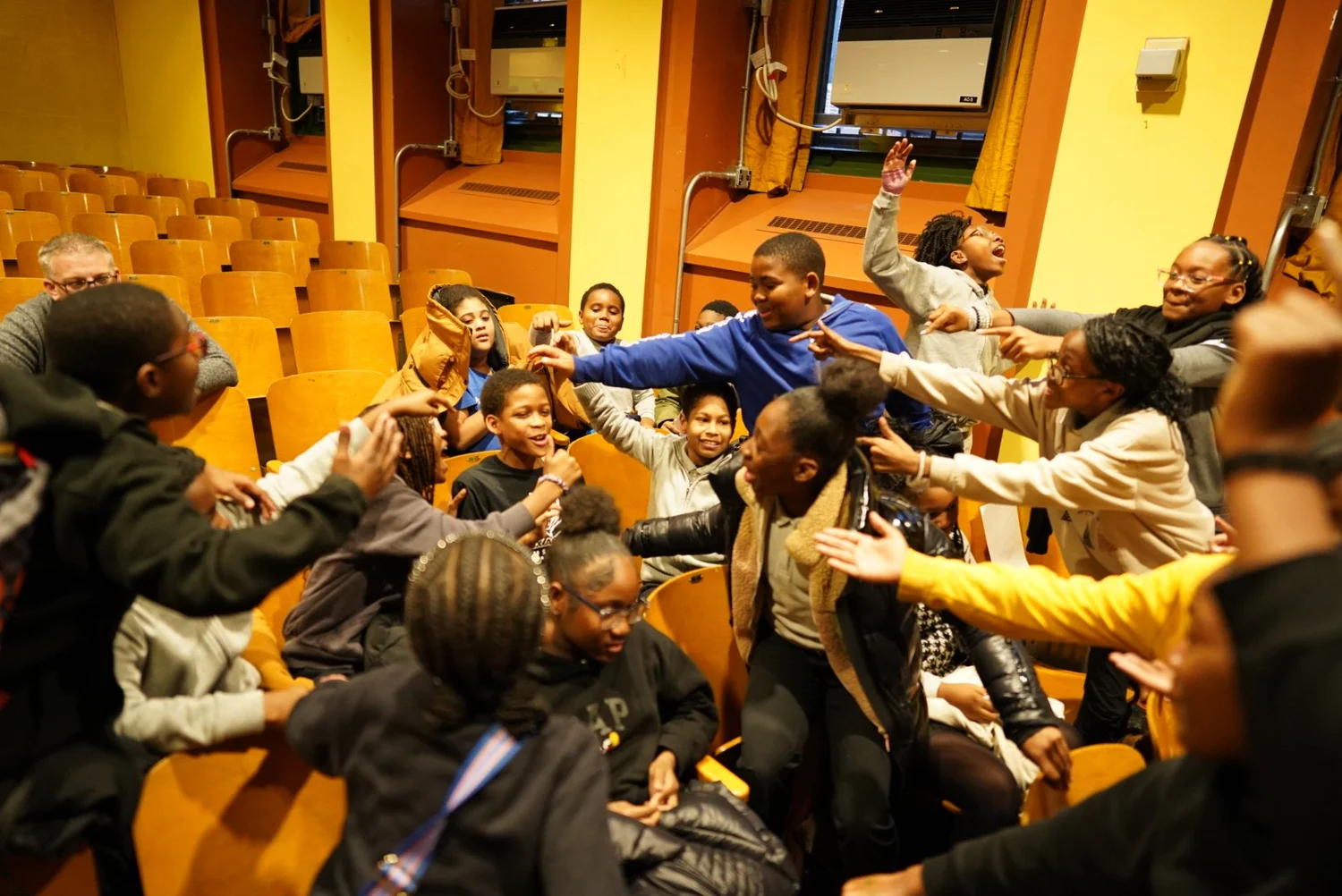 Group of children animatedly interacting and reaching out to each 