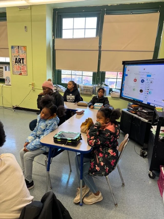 Children sitting around a classroom table with tablets