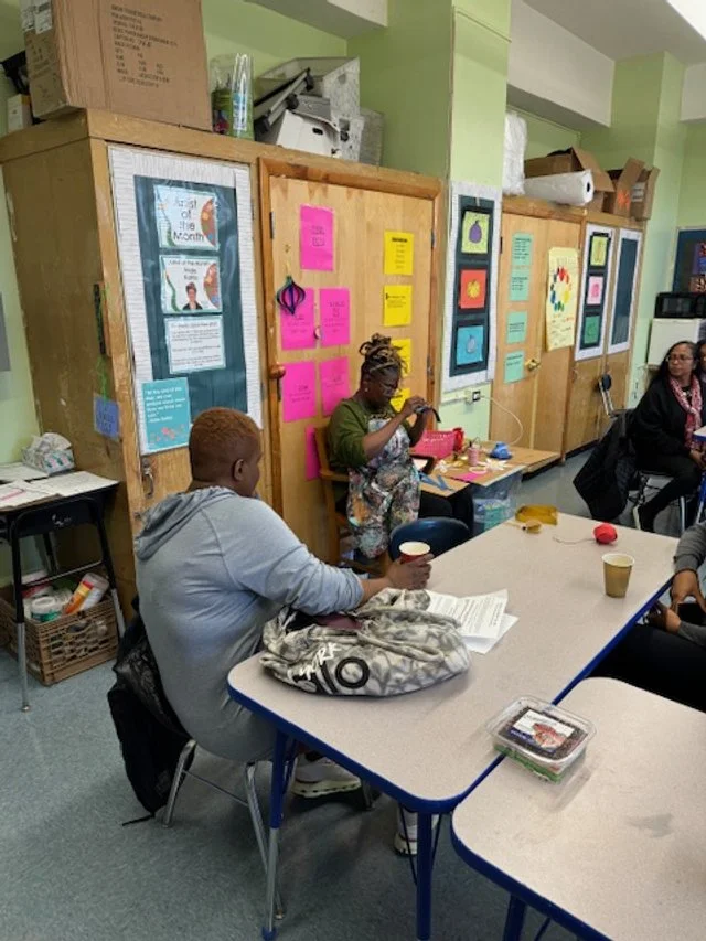 A group of people sitting and engaging in a classroom with colorful posters