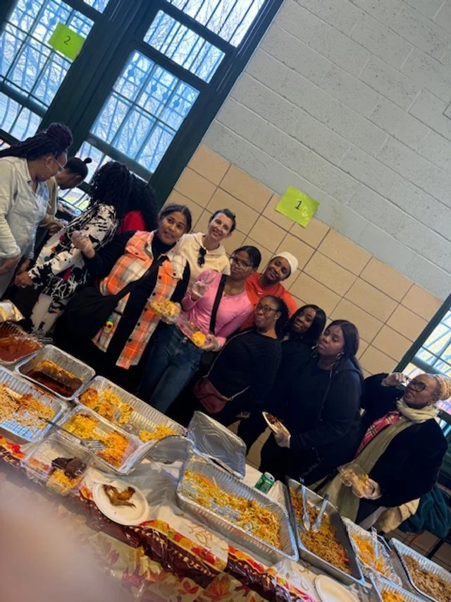Group of people standing behind a table filled
