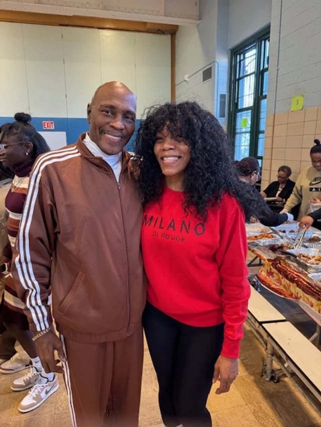 Smiling man in brown tracksuit with white stripes