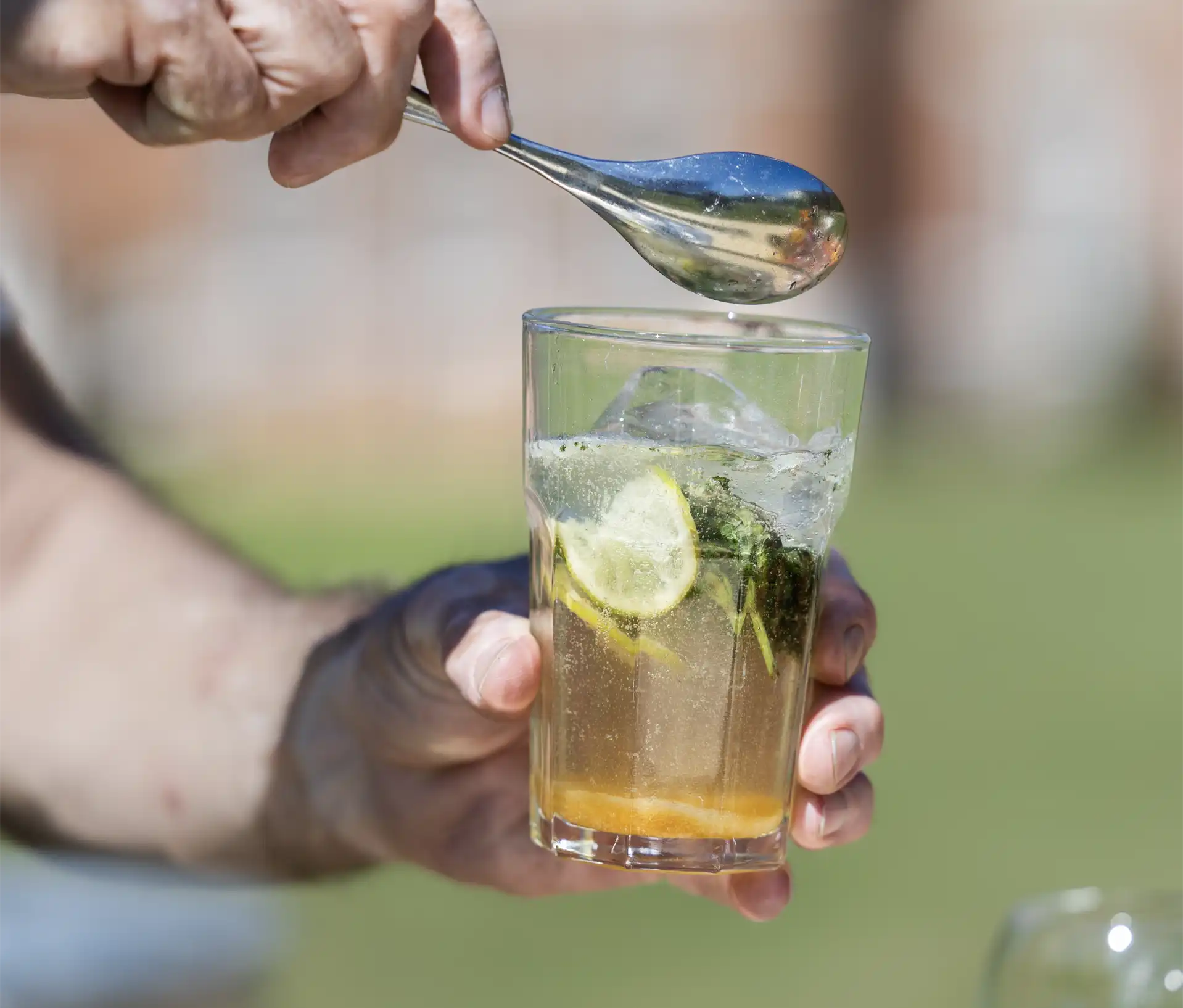 Un cocktail Mojito frais et ses feuilles de menthe sur un buffet extérieur de La Cantine en Folie.