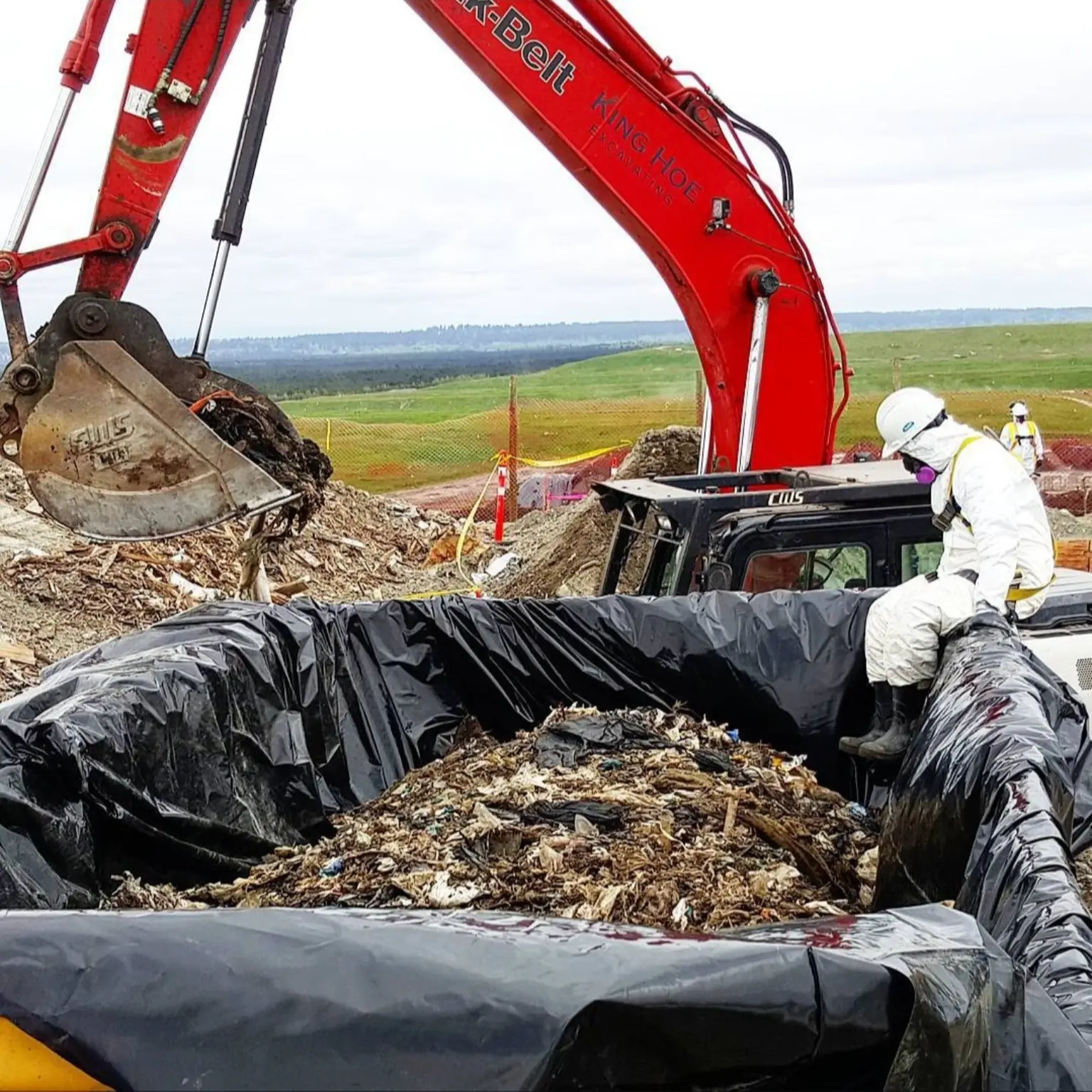 Excavator and crew completing lined environmental remediation work