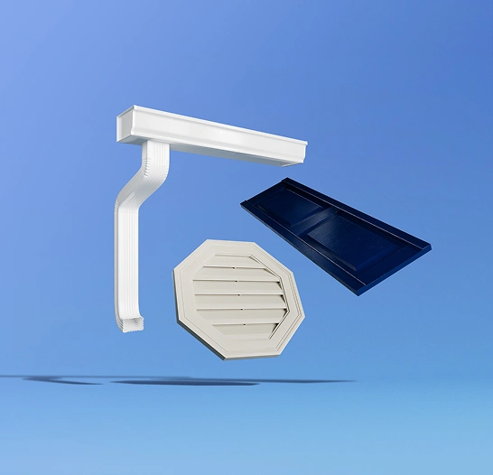 White gutter corner piece, beige octagonal vent cover, and dark blue raised panel cabinet door floating against a blue background.