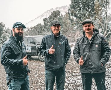 Black Cooleys Heating & Cooling truck parked outdoors under a partly cloudy sky.