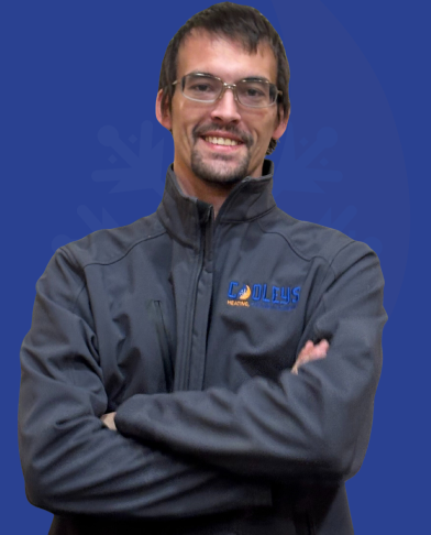 Man with glasses and dark hair smiling, wearing a gray zip-up jacket with a heating company logo on a blue background.