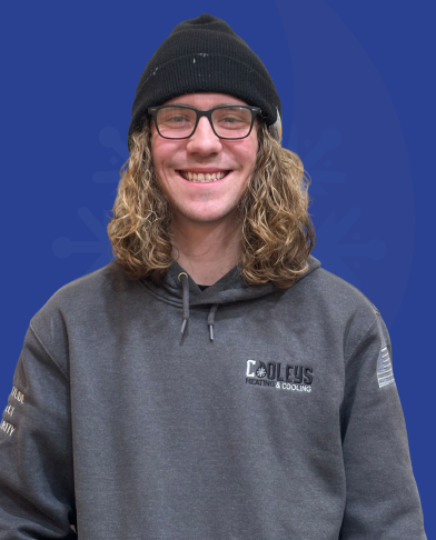 Smiling man with long curly hair wearing glasses, a black beanie, and a dark gray hoodie with Cool Guys Heating & Cooling logo on the front.