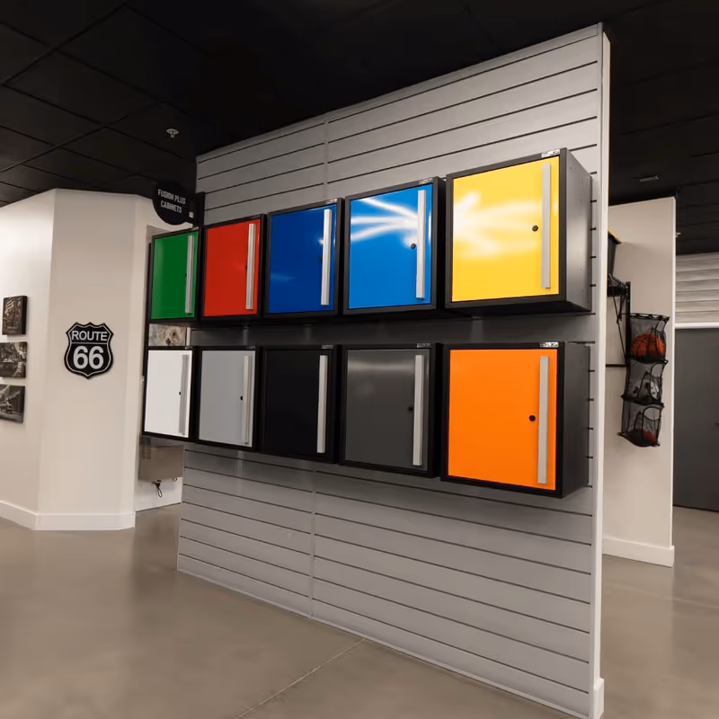 Wall-mounted cabinets in various colors including green, red, blue, yellow, white, gray, black, and orange displayed in a showroom.