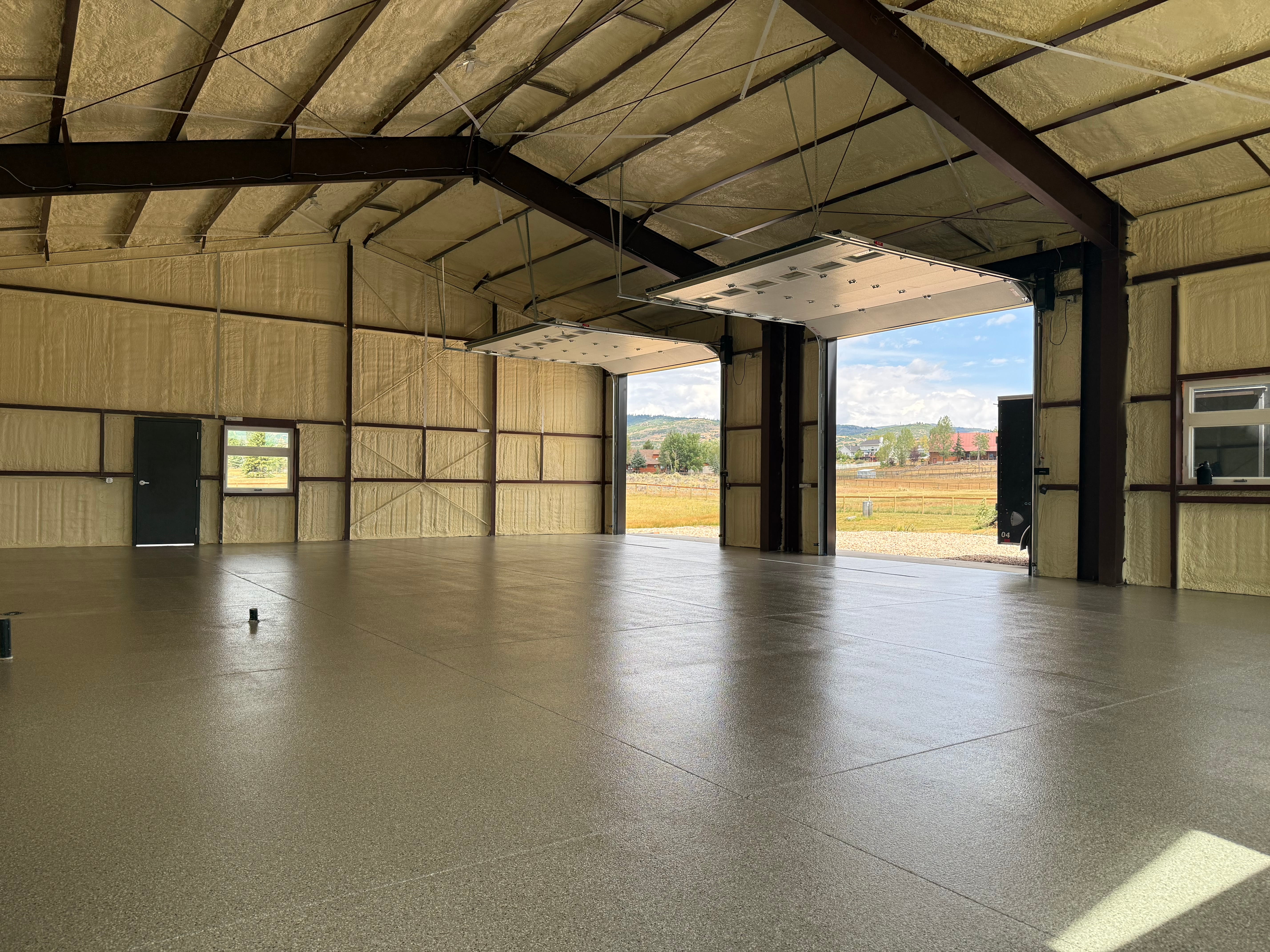 Grey flake floor in a steel building shop with the bay door open