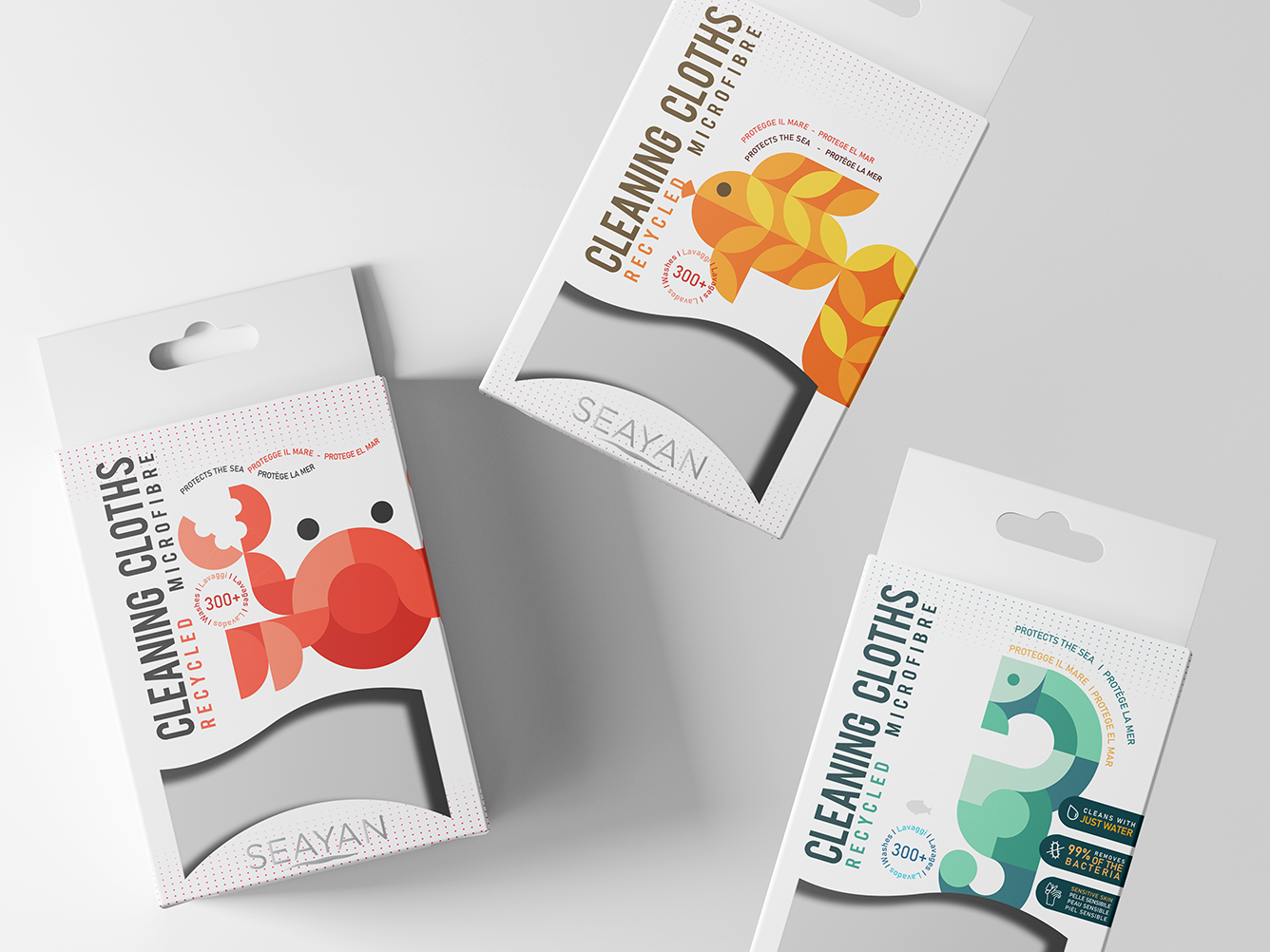 Three packages of Seayan recycled microfiber cleaning cloths with colorful stylized sea animal designs: red crab, orange fish, and teal seahorse.