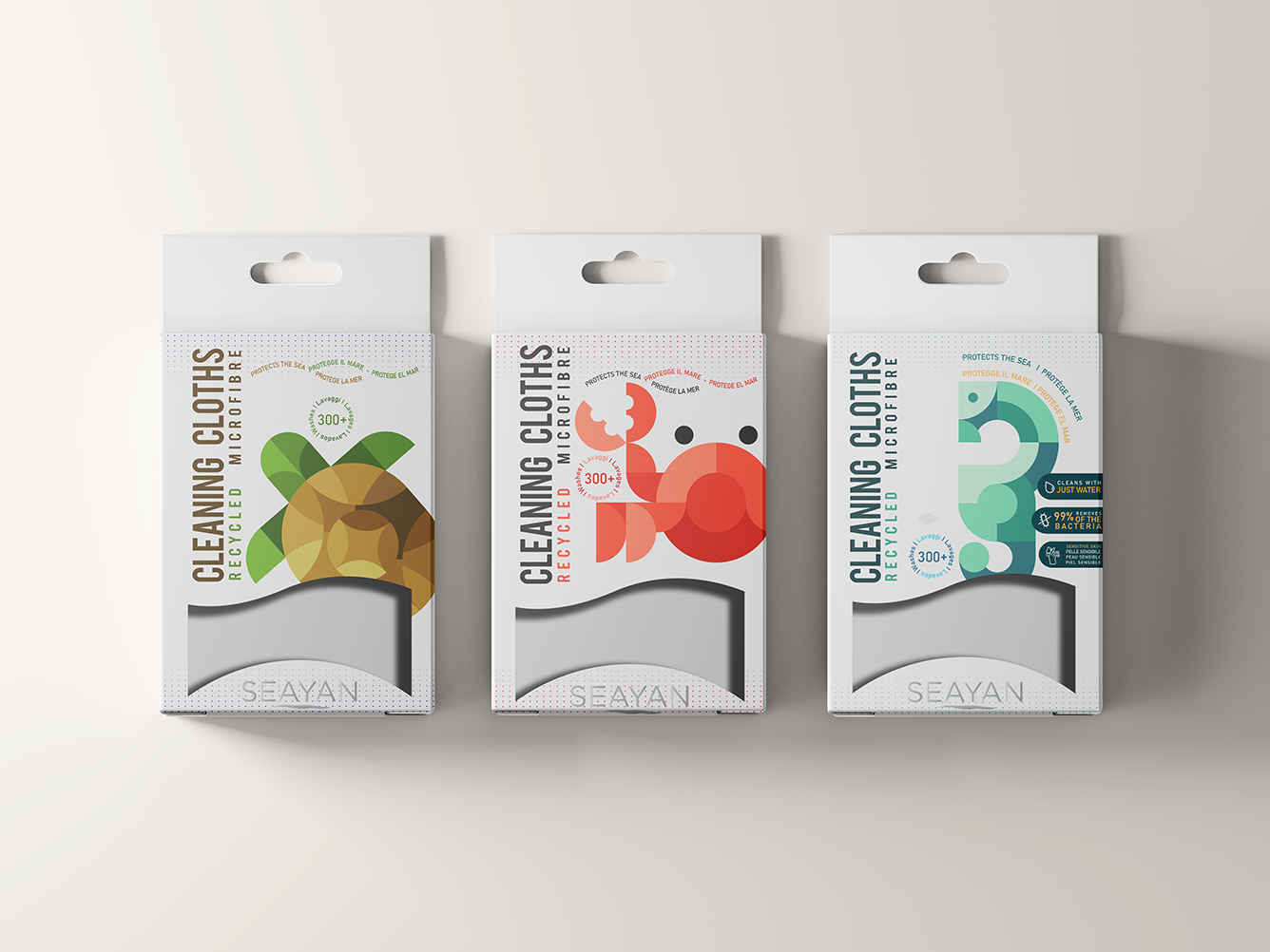 Three packages of Seayan recycled microfibre cleaning cloths featuring geometric animal designs: a green and brown turtle, a red crab, and a blue-green seahorse.
