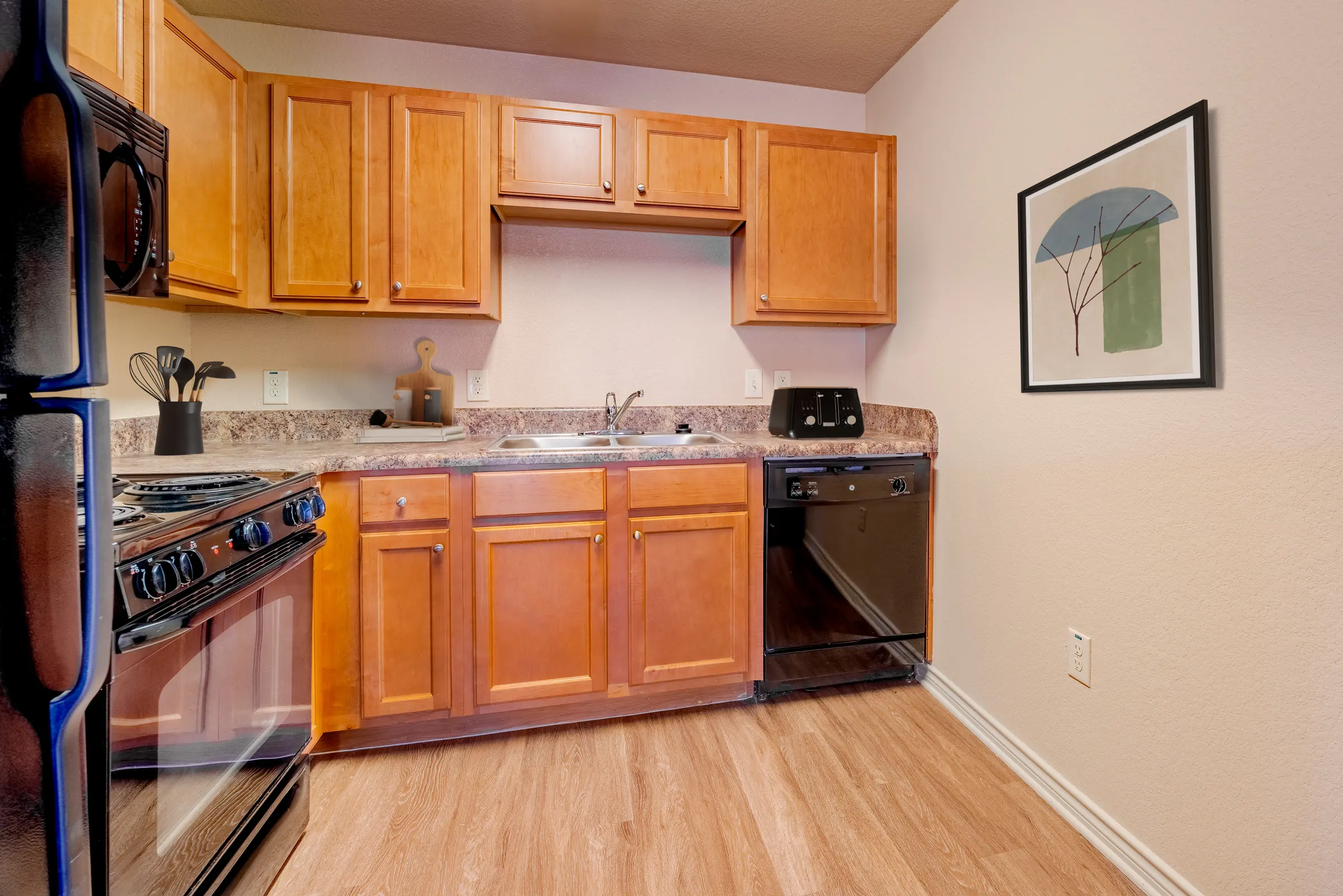 Kitchen with brown cabinets and black appliances