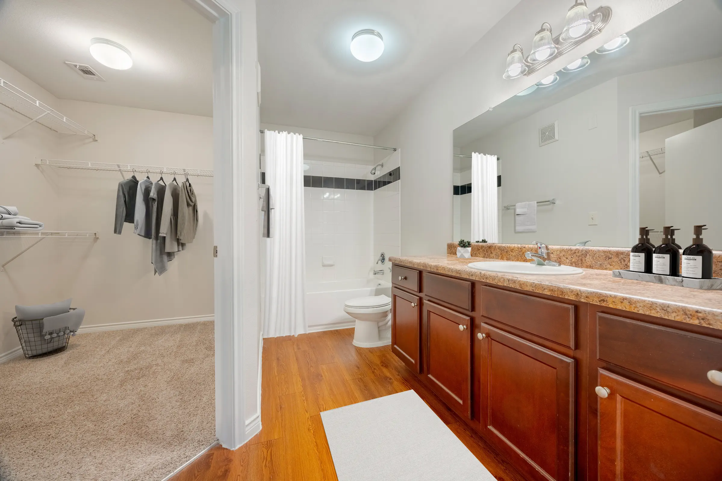 Bathroom with vanity and entrance to closet
