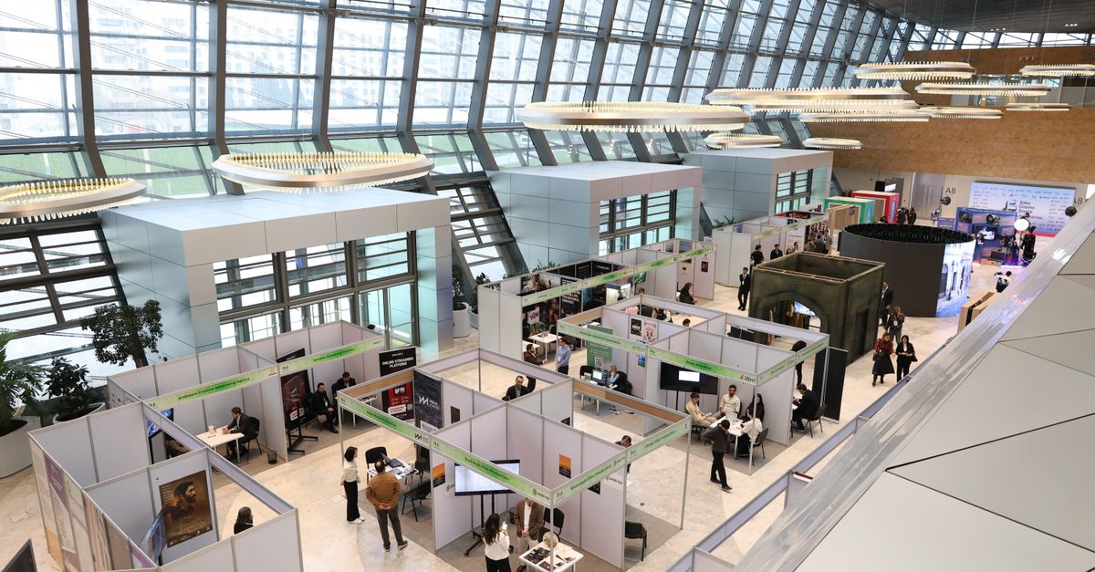 Blick von oben in eine Messehalle mit Ausstellerständen