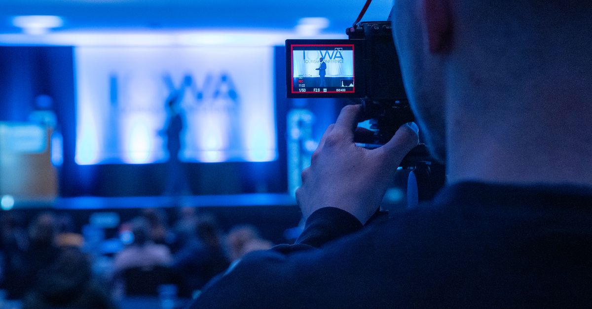 Kameramann filmt eine blau beleuchtete Bühne