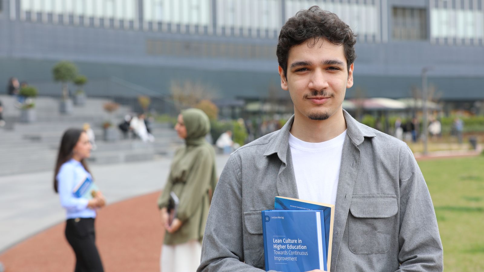 Studierende mit Unterlagen auf dem Campus