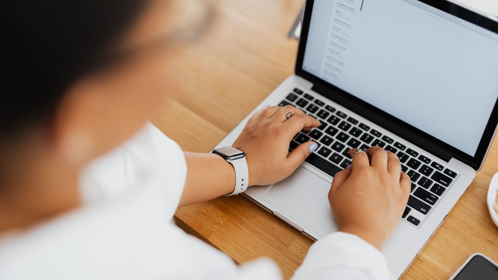 Hände tippen einen Text auf einer Laptoptastatur