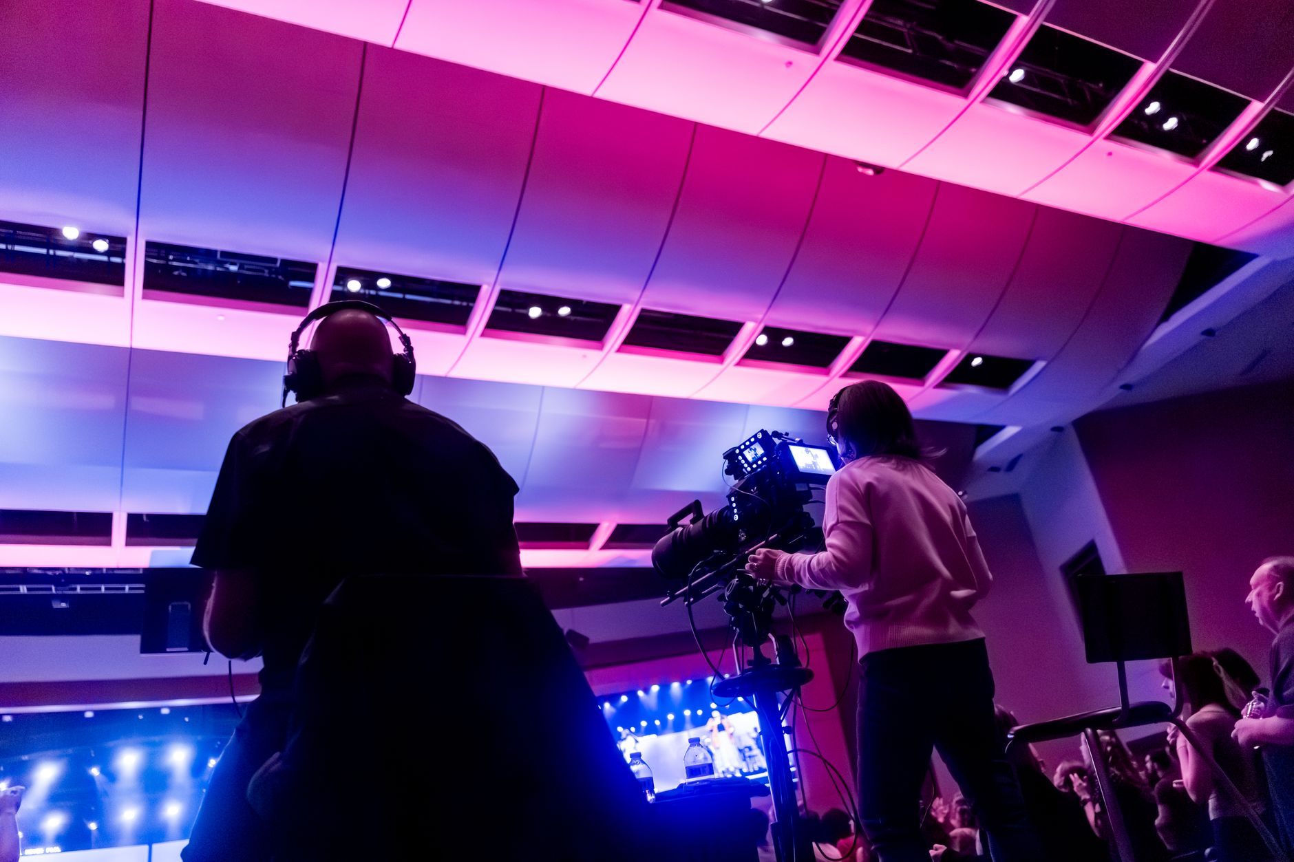 Kamerateam filmt eine Bühnenveranstaltung in einer Halle