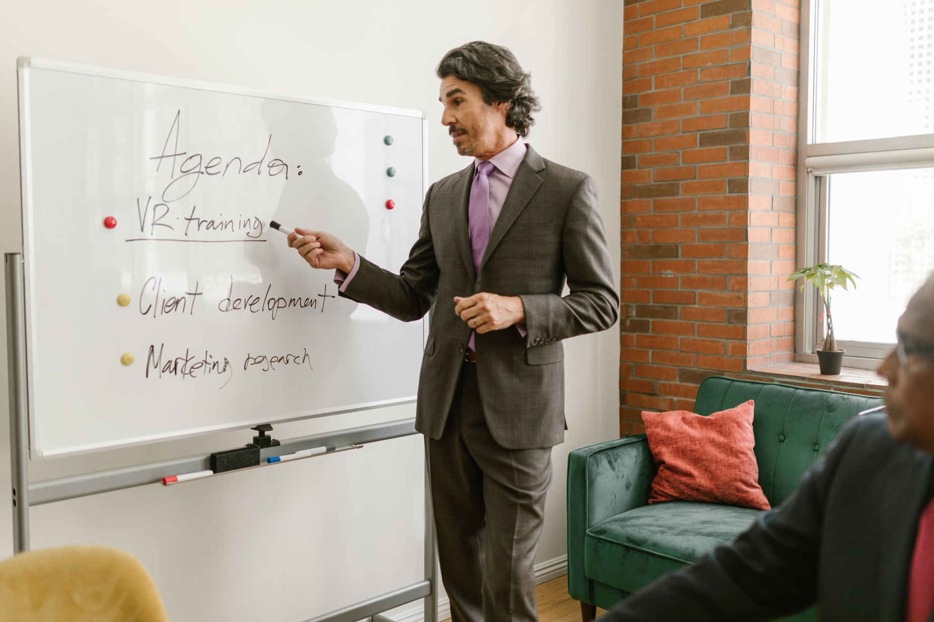 Person präsentiert an einem Whiteboard vor Zuhörern