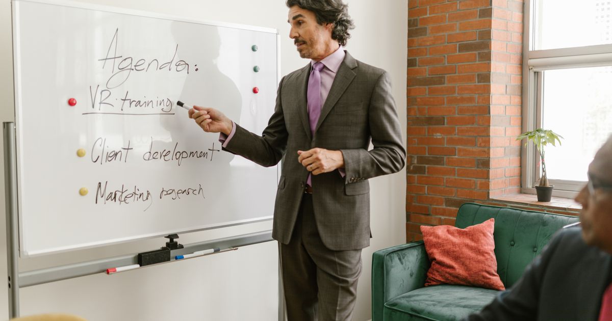 Person präsentiert an einem Whiteboard vor Zuhörern
