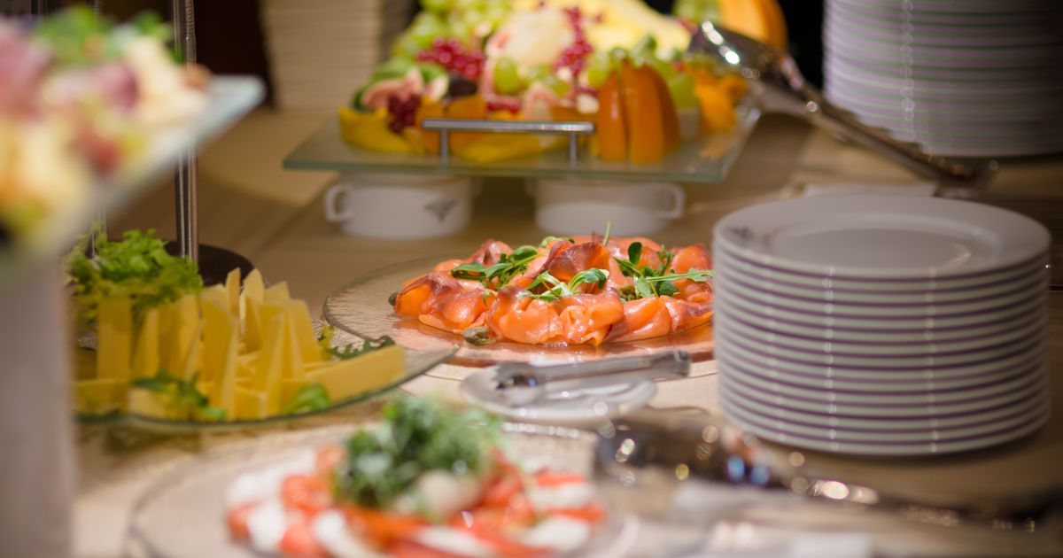 Buffet mit Räucherlachs, frischem Obst und Käseplatten