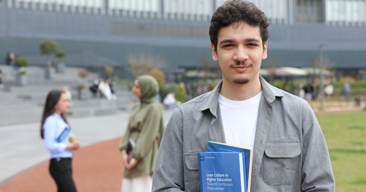 Studierende mit Unterlagen auf dem Campus