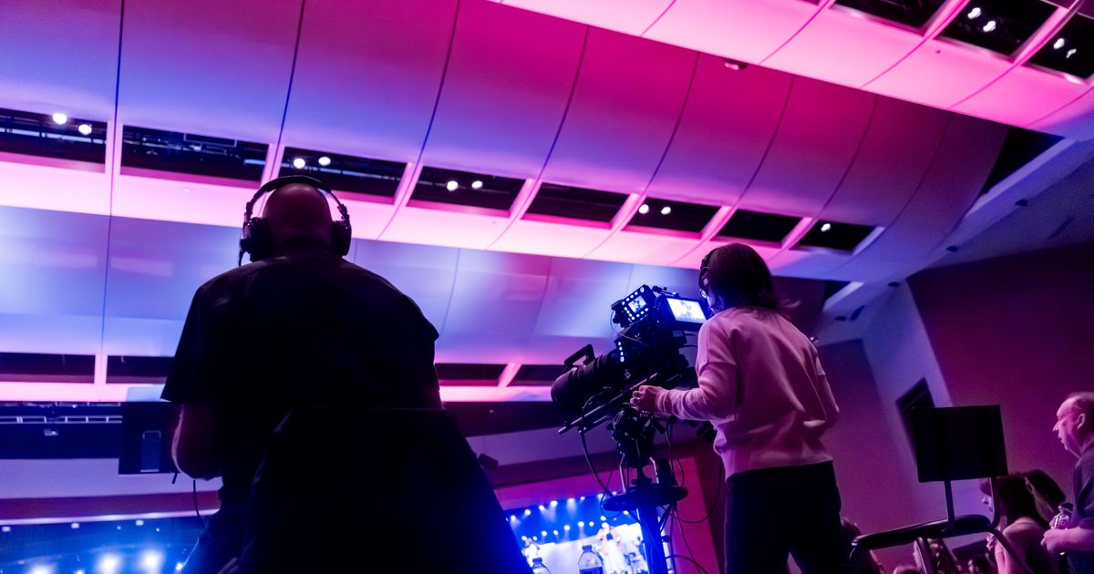 Kamerateam filmt eine Bühnenveranstaltung in einer Halle