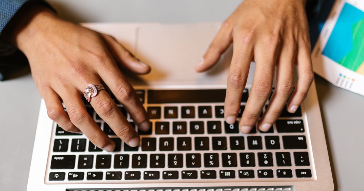 Hände tippen auf einer Laptoptastatur