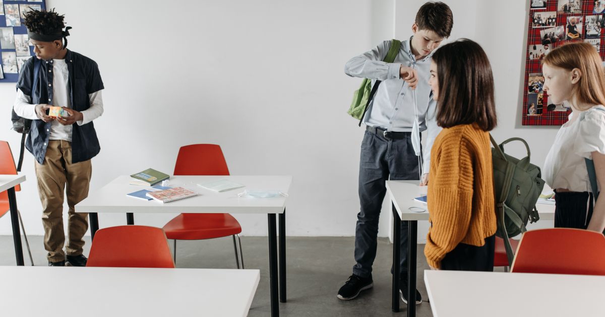Schülerinnen und Schüler stehen in einem Klassenraum