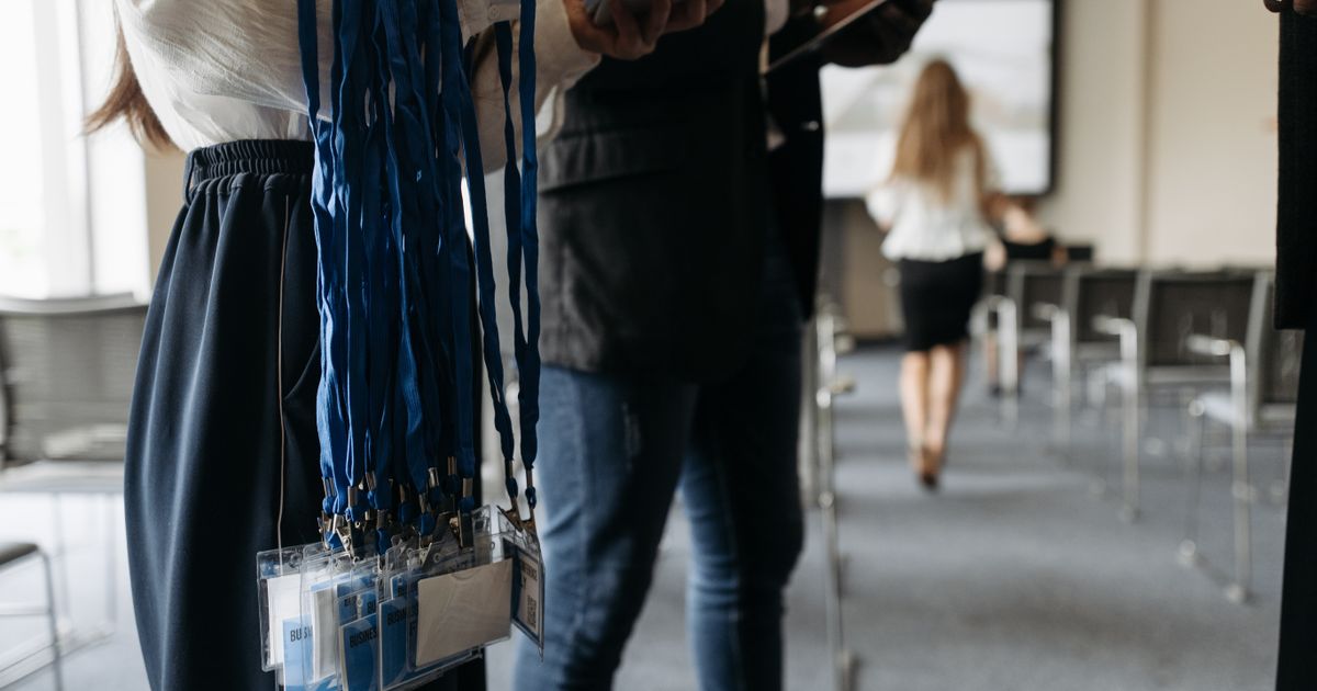 Menschen mit Namensschildern und Lanyards vor einer Veranstaltung