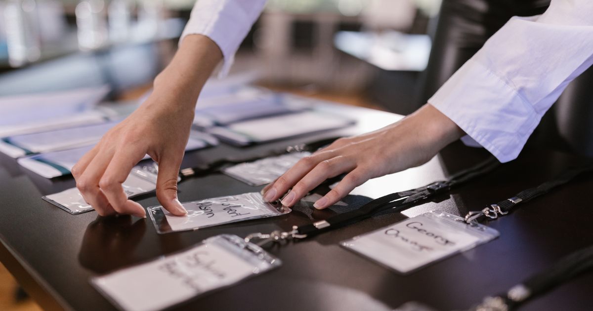 Hände ordnen Namensschilder auf einem Konferenztisch